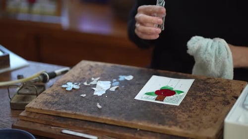 A woman making a stained glass work