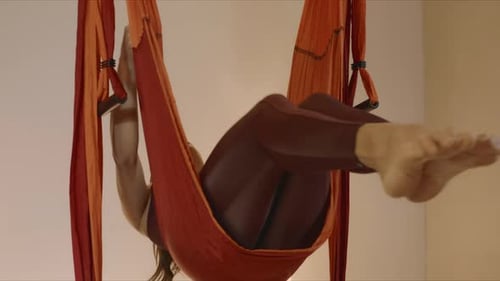 Athletic woman performing aero yoga in slow motion at a fly yoga studio