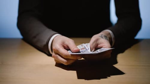 Counting Money Dollar Bills at Table