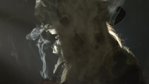 Mysterious Figure Smoking Pipe in Dark