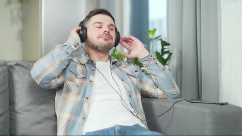 Man Relaxing at Home Listening to Music