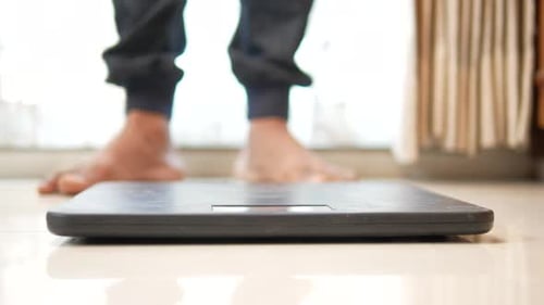 Man's Feet on Weight Scale Close Up