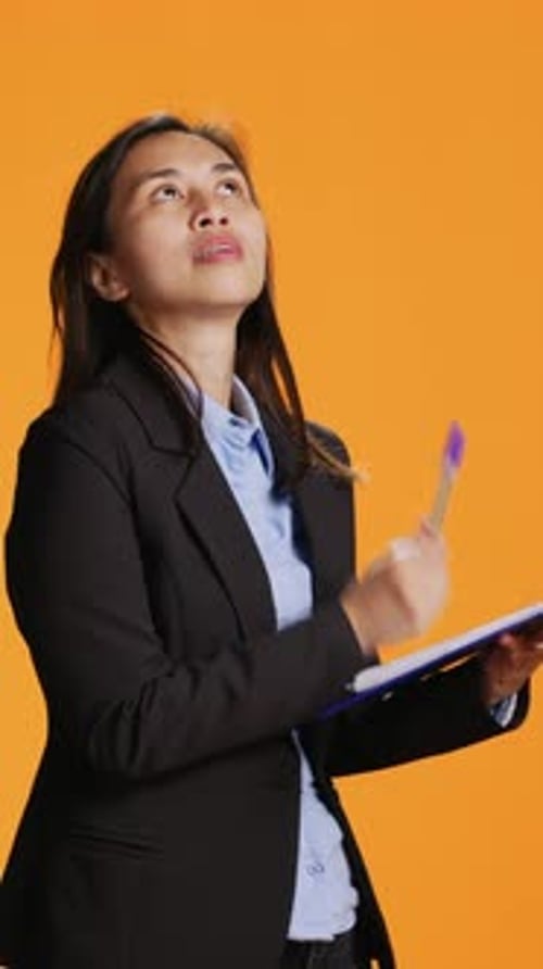 Vertical Video Asian Manager Writes Important Data on Papers with Clipboard