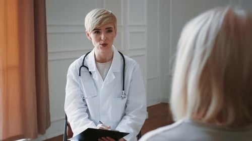 Doctor Conducts a Consultation With a Patient in a Modern Medical Office Setting in Video Footage