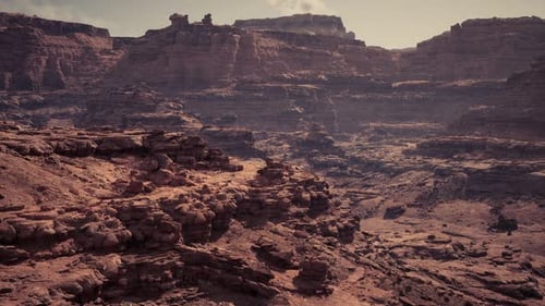 Vast Arid Landscape with Rugged Rock Formations During Golden Hour