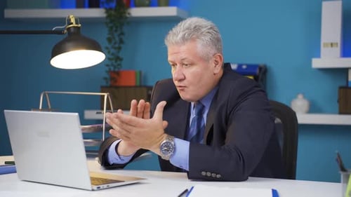 Man Works at Desk and Uses Laptop