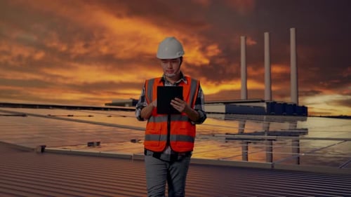 Asian Male Use Tablet While Walking and Inspecting Solar Rooftop