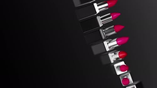 Twisted Row of Lipstick with Various Red Tints Rotating Against Black Background Black Package with