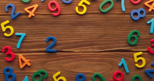 Child Hand Puts Colored Numbers 2023 New Year on Wooden Background