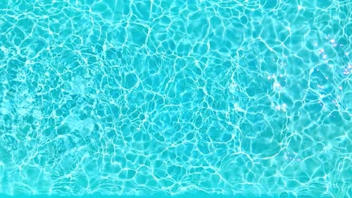 Blaues Wasser im Schwimmbad mit Lichtreflexen in Zeitlupe