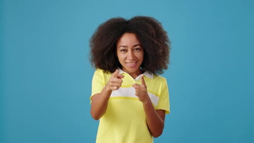 Smiling Woman Playfully Points Fingers at Camera