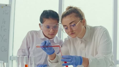 Woman Demonstrates Scientific Experiment to Child in Lab