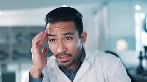 Stressed Doctor Rubbing Temples in Bright Lab