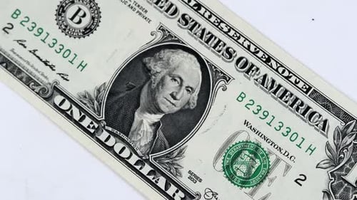 One 1 dollar bill national currency of USA spinning on white background close up.