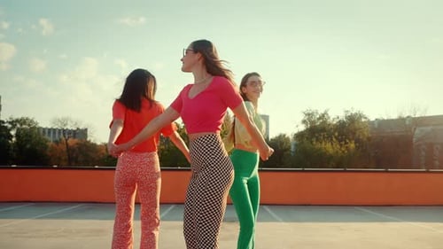 Positive Stylish Women Spinning in Circle on Quad Rollers