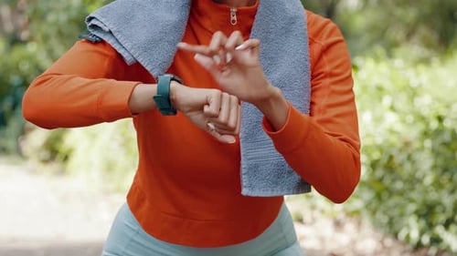 Woman Checks Smartwatch While Standing Outdoors