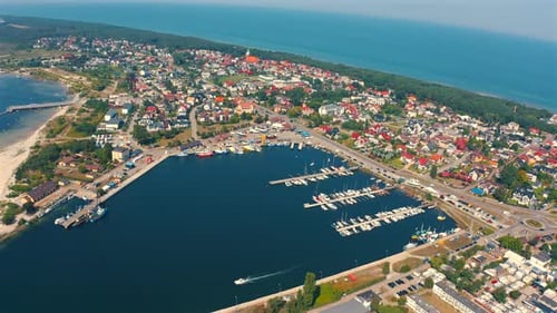 Panoramic view of drone flying above the city of Jastarnia with marina and yachts and baltic sea in