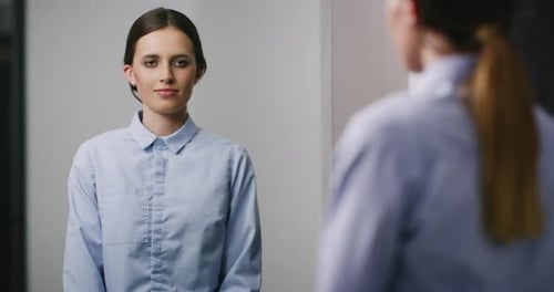 Paciente femenina con esquizofrenia que mira su reflejo en el espejo en un manicomio