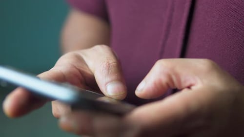 Close Up of Male Hands Typing on Smartphone Screen With Both Thumbs