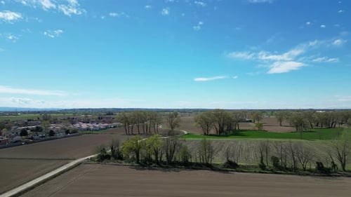 Drone flies over freshly cultivated fields in the Po Valley on a sunny spring day