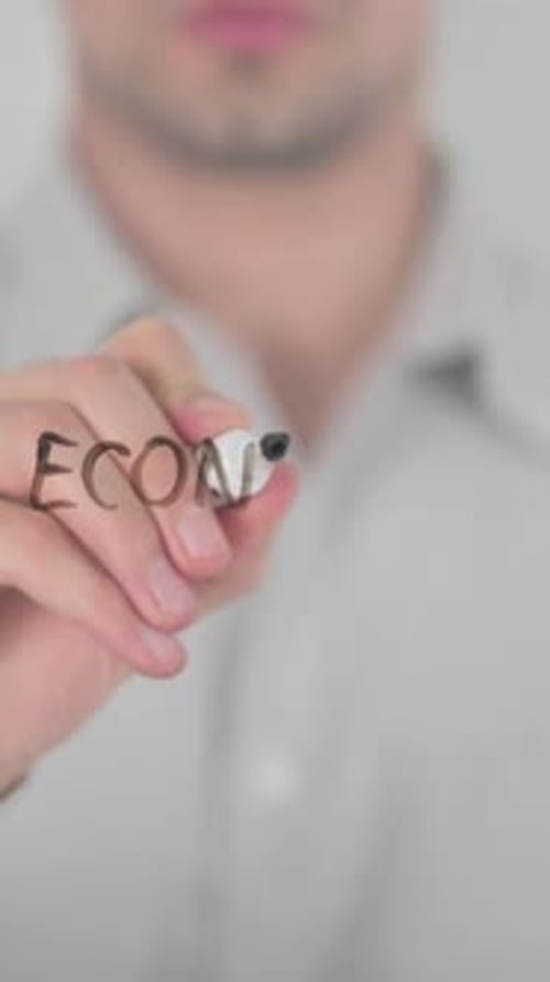 Writing Economic Cooperation on Glass Board in Studio