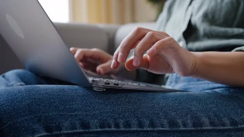 Young Woman Works Remotely Typing on Computer at Cozy Home