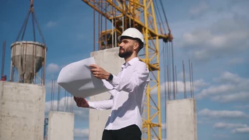 Construction Worker Holding Blueprint on a Sunny Day