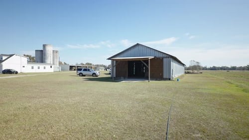 Corrugated iron construction barn on farmland gimbal shot