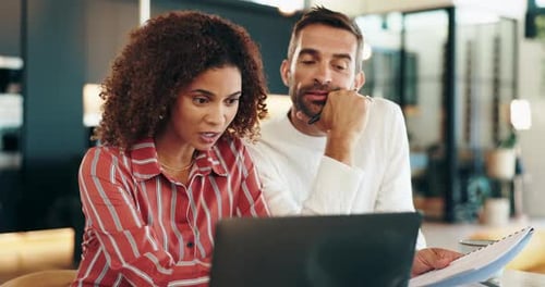 Colleagues working together using laptop in office