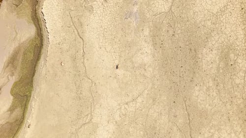 Topdown aerial of figure walking across vast dry lakebed in Greece