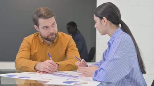 Business Colleagues Analyzing Data Together at Table