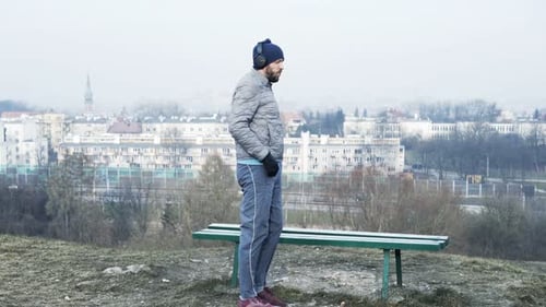 Man Jogging And Using Smartphone In City Park