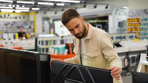 Customer Examining a Discounted Television in an Electronics Store