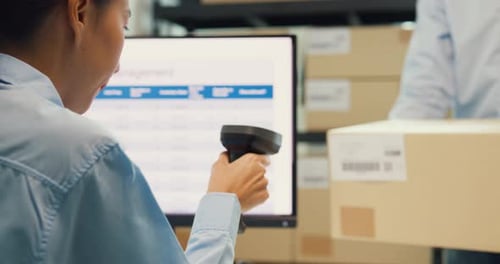 man hold cardboard box and girl use barcode machine scanner stock online data at warehouse.