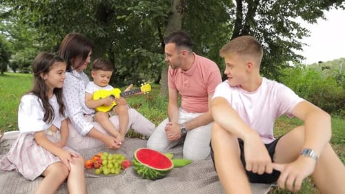 Smiling Big Friendly Family with Children Spending Time Together at Picnic at the City Park