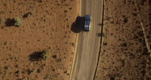 Desert road, car driving and aerial view with drone in Arizona with landscape and countryside