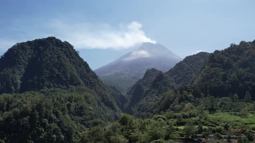 Active Volcano with Lush Green Mountain Range
