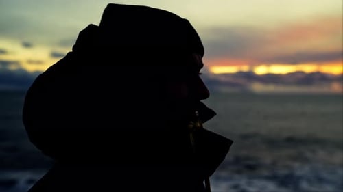 Side View Of A Man Looking At The Sunset Over The Horizon