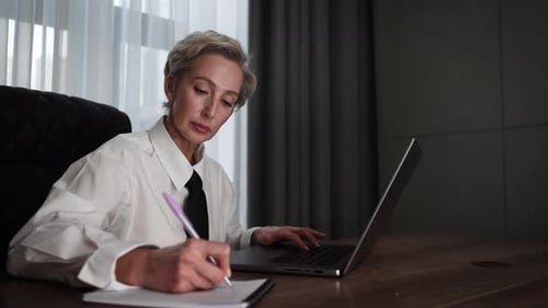 Focused Middleaged Business Woman Using Computer Remote for Business Studying Watch Online Virtual