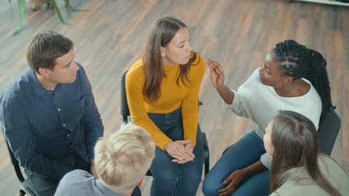 Vue d'en haut d'un groupe de personnes assises en cercle pendant une thérapie de groupe