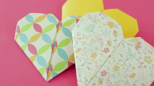 Beautiful Origami Hearts on Pink Background