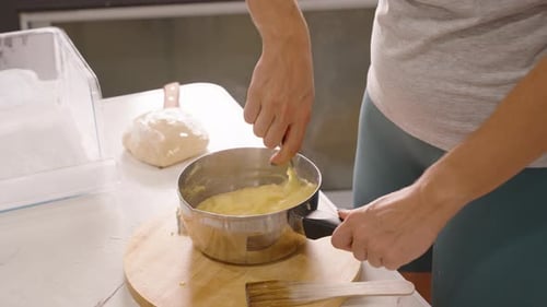 Woman Stirring Custard in Kitchen at Home
