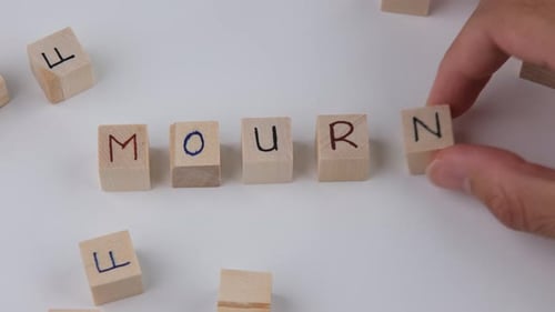 Wood Blocks Spelling the Word Mourn