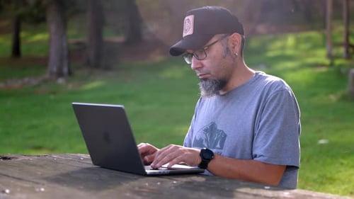 Focused Typing on Laptop in a Rural Park