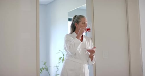 Woman in Robe Drinking Beverage Indoors