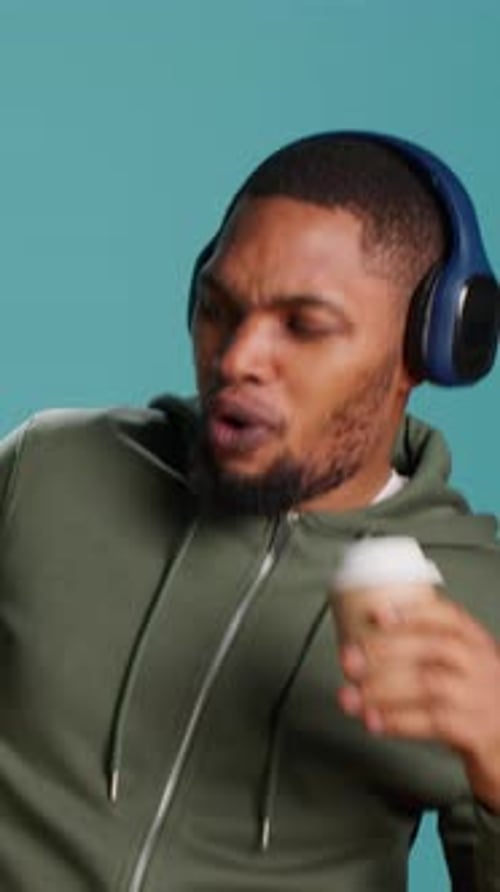 Man With Headphones Drinking Coffee and Dancing