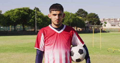 Video of biracial male football players with ball on field