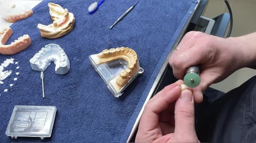 Close Up Of Professional Technician Using Tool To Cut Artificial Dental Model Tooth Tool Cuts