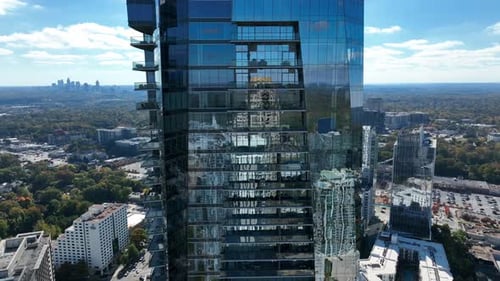 Urban city condo highrise skyscraper building on bright sunny summer day. Rising aerial view.