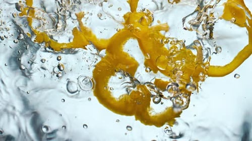 Gelber Pfeffer spritzt Wasser in Superzeitlupe Nahaufnahme